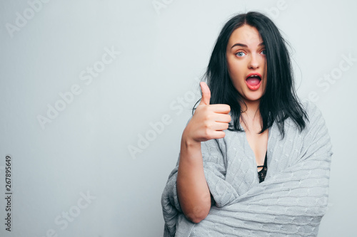 The happy girl in a gray plaid on a gray background shows the class Fototapete
