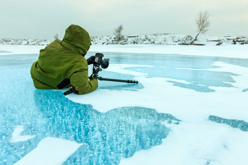 Wall Mural - photographer takes pictures bubbles of methane gas frozen into clear ice lake baikal, russia