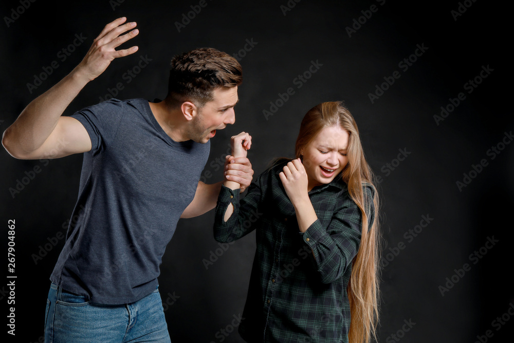 Young quarrelling couple on dark background
