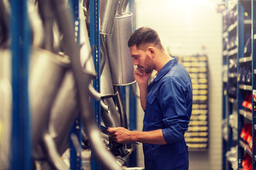 Wall Mural - car service, repair, maintenance and people concept - auto mechanic man or smith with clipboard at workshop or warehouse