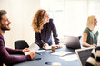 © Flamingo Images - Young businesswoman laughing with coworkers in an office
