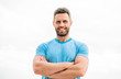 muscular male with beard. happy man isolated on white. sportsman with athletic body. coach in fitness gym. after workout. man athlete in blue sport tshirt. sportswear fashion. happy smiling man