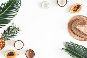 Summer composition. Tropical palm leaves, hat, coconut, pineapple, papaya on white background. Summer concept. Flat lay, top view, copy space