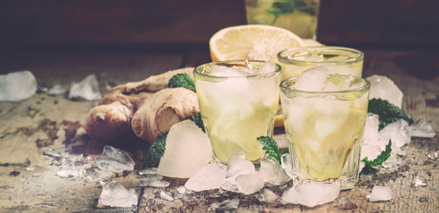 Wall Mural - Ginger tea with lemon, ice and mint, summer drink, selective focus