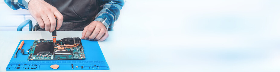The repairman works in technical support, is engaged in the restoration and cleaning of the laptop.