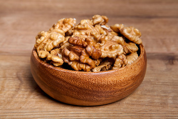 Walnut in a bowls on wooden table. Healthy food and snack.