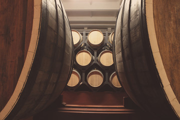 Fototapete - Wooden barrels with whiskey in dark cellar. Modern production of whiskey with the observance of age-old traditions.