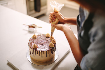 chef decorating cake with cream