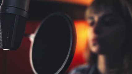 Wall Mural - Female singer with microphone recording a song in music studio