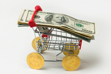 Grocery cart with Bitcoin wheels. The concept of technological breakthrough, online shopping.	