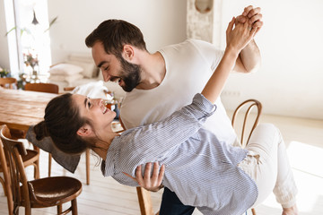 Wall Mural - photo of content brunette couple in love smiling while hugging together in apartment