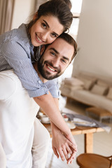 Wall Mural - photo of attractive brunette couple in love smiling while hugging together in apartment