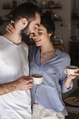 Wall Mural - Happy young couple having cup of tea