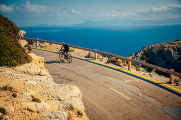 Sticker - Athlete on road bicycle ride by the sea Sport in beautiful nature.