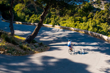 Wall Mural - Triathlete men cycling road bike in the summer evening