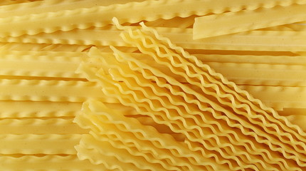 Uncooked Italian pasta mafaldine background and texture, top view