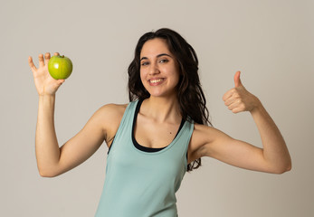 Portrait of happy fitness young latin woman with apple after workout training