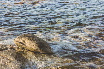 Wall Mural - gray waterfront mountain river stream with stone and water surface and small waves surface simple nature background 