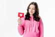 © LIGHTFIELD STUDIOS - pretty young girl in pink hoodie holding red paper cut card with heart symbol isolated on white
