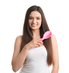 Wall Mural - Beautiful young woman with hair brush on white background