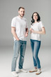 © LIGHTFIELD STUDIOS - young man and woman in white t-shirts and blue jeans looking at camera on grey background