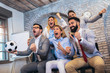 © Mediteraneo - Happy business people or football fans watching soccer on tv and celebrating victory. Friendship, sports and entertainment concept.