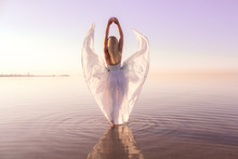 Woman In White Dress Standing In Body Of Water