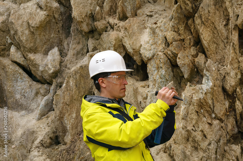Fotografía geologist examines a sample of stone outdoor