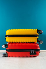 Bright and stylish cabin size suitcases as holiday concept agains dark blue background, copy space. Easy travel with little baggage