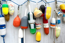 Lobster Buoys Hanging On White Fence