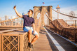Tourist model taking a selfie on a Brooklyn Bridge