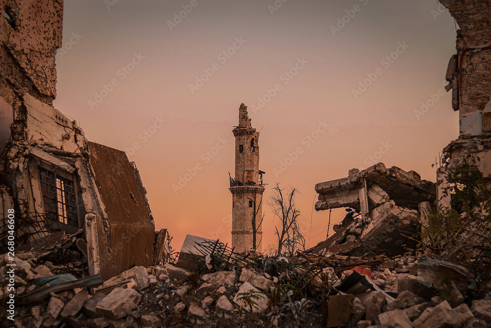 Destroyed buildings next to a mosque in the city of Aleppo in Syria - obrazy, fototapety, plakaty 