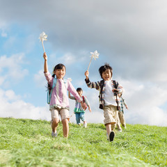 Poster - 風車を持ち草原を走る小学生