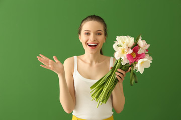 Wall Mural - Happy young woman with bouquet of beautiful tulips on color background