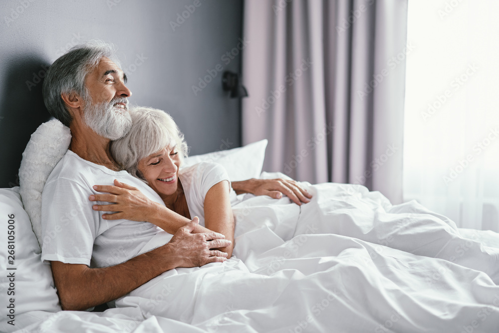Happiness and tender. Senior family. Husbang hugging his wife in bed. - obrazy, fototapety, plakaty 