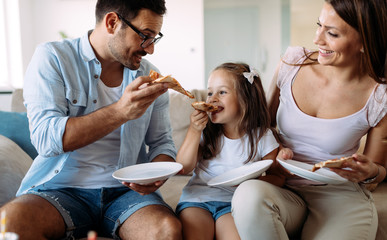 Portrait of happy family sharing pizza at home