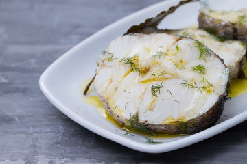 boiled fish with olive oil  and bay leaf in white dish