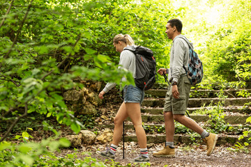 Wall Mural - young couple hiking in nature.they enjoying in walk and fresh air.