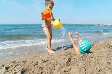 Wall Mural - sister bringing water to brother on beach