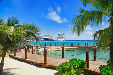 Wall Mural - View from beach at tropical resort on cruise ships docked at port 