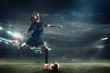 © master1305 - Young female soccer or football player with long hair in sportwear and boots kicking ball for the goal in jump at the stadium. Concept of healthy lifestyle, professional sport, hobby, motion, movement