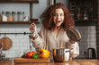 © Drobot Dean - Photo of excited caucasian woman holding cooking ladle spoon while eating soup at home