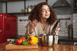 Photo of vegetarian caucasian woman holding cooking ladle spoon while eating soup in kitchen at home