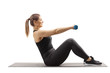 © Ljupco Smokovski - Young woman sitting on an exercising mat and working out with dumbbells