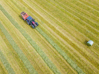 Sticker - Aerial view of tractor harvesting green hay from meadow.