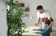 © New Africa - Dad helping his son with school assignment at home