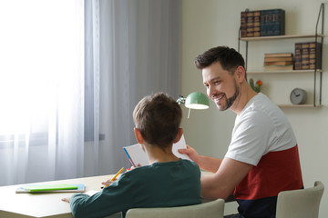 Poster - Dad helping his son with school assignment at home