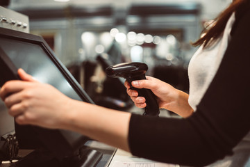 Young woman hand doing process payment on a touchscreen cash register, finance concept (color toned image)