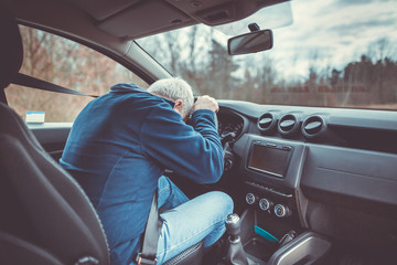 Man driving car and falling asleep at the wheel, transportation concept