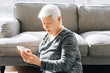 © MaaHoo Studio/Stocksy - Aged woman using smartphone at home